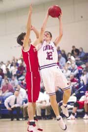 Sophomore Todd Roberts goes in under the basket as his Ottawa
opponent tries to block the shot. The Cardinals defeated the
Cyclones 58-56 in the last few seconds of the game.