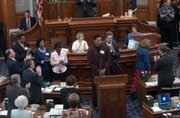 Leavenworth native Wayne Simien, center at podium, is congratulated on the floor of the Kansas House of Representatives for being named to the All-America basketball team. On hand for the ceremony Wednesday were Rep. Kenny Wilk, R-Lansing, and Candy Ruff, D-Leavenworth, members of Simien's family, left and University of Kansas basketball coach Bill Self, behind Simien. A similiar ceremony was held in the Kansas Senate.