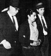 In 1959, Kansas Bureau of Investigation agents Clarence Duntz, left, and Al Dewey, right, bring Perry Smith to court.