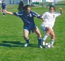 Displaying some fancy footwork, De Soto's Jordan Holden controls
the ball under pressure from a Lawrence Bishop Seabury opponent
during the Wildcats' win last Thursday. Holden scored her first
goal in the match and scored again Tuesday against Maranatha.
