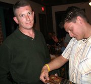 Mark Alligood, left, shows his Fireman of the Year plaque to fellow Leavenworth County Fire District No. 1 firefighter Nick Ontiveros on Saturday night, April 30, at La Mesa, 710 N. Main St. The Lansing Kiwanis Club and the fire department honored firefighters and their significant others at a Partners Appreciation Dinner at the restaurant.