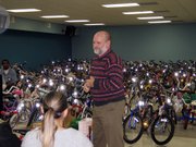 Lansing Correctional Facility Warden Dave McKune stands in front hundreds of bikes refurbished by prisoners and on their way to new homes.