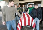 A team of pallbearers, made up of past and present basketball
players, guide the casket with the body of their former coach and
Vietnam veteran following the church service.