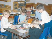 Student Sean Toplikar reads a book to teacher Marilee Quinn.
Because of the small class sizes, Quinn is able to give each
student individual attention and teach the students in a way that
works best for them.