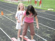 Jordan Maestas, left, and Tara Dupras, Lansing Intermediate School fourth-graders, try out one of the events at Field Day on Friday, May 5, at Frank Graham Field.