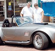Dale Enick and his son, Jacob, look at a Shelby Cobra during the
car show portion of Saturday's Planes, Trains and Automobiles in
downtown Baldwin City.