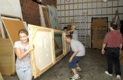 Lansing High School drama club students move props out of the club's storage shed last month. The shed is being relocated to make a parking lot once construction commences on the new high school auditorium.