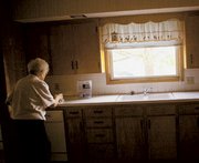 Eva Belle Gerstenberger tidies up the kitchen of her old house. The
Gerstenbergers have spent the past three weeks moving.