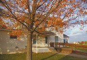A bright orange tree highlights the yard of the Gerstenberger
house. The two-story, five-room home was originally a wedding
present.