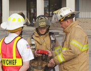 Eudora City Fire Chief Randy Ates, volunteer firefighter Damon
Bradley and Deputy Fire Chief Mike Underwood study readings Friday
on a gas detector after investigating a reported leak at the
C&S Market complex. Later, Atmos Energy confirmed seven
different leaks in the complex. Each leak was small, Ates said.