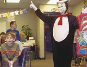 Logan Clancy, Nicole Rodgers,Drew Schmucker and Bailey Steele
listen as the Cat in the Hat, or reading specialist Tara Priddy,
visits their Starside classroom Friday to announce a reading
challenge. The winning classroom will earn the pinata.