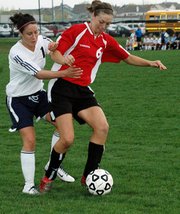 Christine Cordes, Lansing High junior, shields the ball from Mill Valley's Jennifer Volmer during Lansing's 3-2 victory Tuesday.
