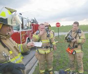 Greg LeRow reads a new complication handed to the Eudora City Fire
Department May 9 during training. The volunteer firefighters fought
a mock house fire during the session.