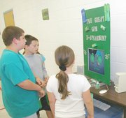 A group of fair-goers gathers around the "The Great Gum
X-Spearment" by fifth-graders Jenae Koplin and Claudia Moody. The
experiment won first place in its class. Students and their
families had the opportunity May 9 to see the projects in the
schoolwide fair.