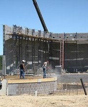 Construction crews work on the stage floor of the new Lansing High auditorium. All preliminary in-ground work is finally completed, so crews have begun to put up walls.