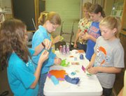 After listening to an episode of the radio drama "The Shadow,"
participants in the Eudora Public Library's summer reading program
work on a craft project.