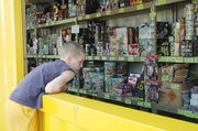 Elijah Hill, Leavenworth, looks over the counter picking out fireworks to buy at the Lunatics Fast-Pitch Softball fireworks stand in Lansing in this 2007 photo.