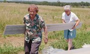 Doris Oelschlaeger and Dorothy Westerhouse bring a plank to be used
inside the church. Congregation members came throughout the day
Saturday to help out.
