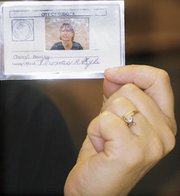 Eudora City Administrator Cheryl Beatty holds a laminated
identification card. Each of the city's 45 employees were issued a
similar card last week. The cards give citizens a way to prove city
employees are who they say they are and the city a way to control
who has access to a disaster area.