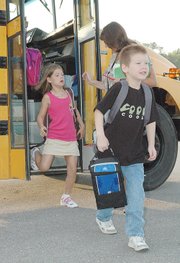 Students step off the bus on the first day of classes Wednesday. In a meeting Monday, the Lansing School Board finalized its 2008 budget just in time for the start of the year.