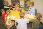 Second-graders read a book Monday with teacher Margaret Peterson.
Peterson's classroom is one of many that was once part of a larger
open space.