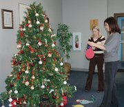 City Clerk Sunshine Petrone, right, and Assistant City Clerk Jennifer VerVoort hang tags on the Angel Tree in the lobby of City Hall, 800 First Terrace. Lansing residents can take a tag, which contains a Christmas wish list of a local underprivileged child, and purchase the items as a gift that will be then be distributed before Christmas.