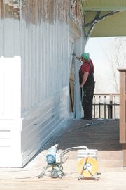 A worker primes the side of the Lansing Historical Museum to prepare the outside for painting. Crews will move inside soon and begin sheetrocking walls.