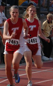 Megan Puhr receives the baton from teammate Andie Jeannin in the girls 4x400 relay Saturday evening.