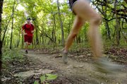 With a canopy of green overhead, runners Nick Foster (left) of Westport and Margaret Hill were part of a group that hit the rolling trails recently at Shawnee Mission Park.