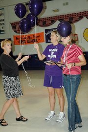 Kathy Gerstner, Baldwin Education Foundation executive director, delivers balloons to Holly Gaylord, center, and Angie Spielman Friday morning. They were given one of the Innovative Project Grants by the BEF.