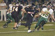 Bonner Springs senior Jonathan Walker (1) breaks away from the Basehor defense and carries the ball for one of his three touchdowns for the night