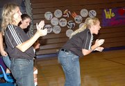 Baldwin High School volleyball coaches Nikki Burnett, left, and Kelly Brown applaud the Bulldogs during last week's match against Tonganoxie.