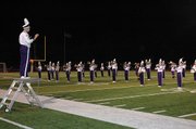 Baldwin High School senior Isaac Twombly, left, leads the BHS marching band in some patriotic songs to kick off the veterans ceremony Friday night.