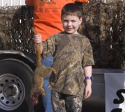 Taylor Whitesell holds up the 1 pound 7 ounce squirrel he helped catch during Saturday's Squirrel Scramble.