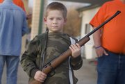 Clayton Bryant, 7, holds the new .22 caliber rifle he won during an auction at Saturday's Squirrel Scramble. The rifle was donated by the Henri Masonic Lodge in Tonganoxie.