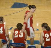 Roni Grizzle pats fellow Tonganoxie High senior Chrissie Jeannin on the back during the final seconds of the Chieftains’ 58-33, season-ending loss to Basehor-Linwood in a sub-state semifinal on Friday.
