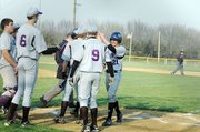 Baldwin High School sophomore Will Von Bargen (No. 21) is greeted by teammates after hitting a home run in the first contest at Ottawa.