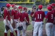 Trailing by three in the third inning, Tonganoxie players listen to caoch Gary Wagner before rallying for a 9-8 victory against the Easton Outlaws on Tuesday at Leavenworth.