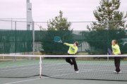 Baldwin High School junior Michaela Krysztof, left, spikes a ball over the net during a match Saturday. Her doubles' partner was sophomore Kara Hoegerl.