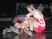Tonganoxie High wrestler Tyler Hand (130) tries to keep his opponent on the mat Saturday at the Baldwin Invitational.