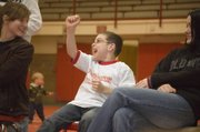Shane Lewis cheers wildly after watching Jonas Myers win a wrestling match on Feb. 4. Shane, a second-grader at Tonganoxie Elementary School, met Myers through a program that sends Tonganoxie High students to the elementary school to work with and mentor young students.
