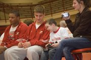 Tonganoxie High sophomore Jonas Myers and Tonganoxie Elementary second-grader Shane Lewis talk on the THS wrestling bench during a home event on Feb. 4. Lewis watched all of the matches from the bench while serving as the team’s water boy.
