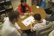 Tonganoxie Elementary School second-grader Shane Lewis works on a reading exercise in the resource room with the help of Tonganoxie High sophomore Jonas Myers and his teacher, Shelby Noonan. Myers, who takes the THS “Leadership in Sports” class, helps Shane with his work one morning each week.
