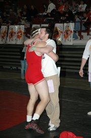 Jeremie Muas is congratulated by Tonganoxie High coach Jeremy Goebel after qualifying for the medal rounds Saturday at the Class 4A state wrestling tournament in Salina.