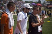 DJ Lindsay, Austin Stone, Jeremy Carlisle and Bret Koch walk around the Cessna Stadium track during a "Champions Lap" ceremony at the state track meet in Wichita on Saturday.