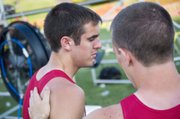 Disappointed about being held out of the 4x400 state championship race, Tyler Woolworth gets a pat on the back from teammate Jeremy Carlisle moments after Tonganoxie finished third in the race.