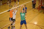 Former Kansas University volleyball player Emily Brown gets underneath the ball for a set as Tonganoxie campers Kailan Kuzmic and Katelyn Waldeier close in on the opposite side.