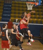 Austin Vickers tries to avoid a Lansing defender on a drive to the rim at the Rockhurst summer league.