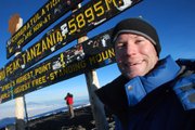 Sports Editor Chris Wristen poses with the sign marking the Uhuru Peak summit, the highest point in Africa, on June 11, 2010.