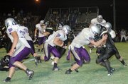 Baldwin High School senior Ryan Rogers, center, follows his blockers during a run up the middle of the Paola defense. Rogers scored one rushing touchdown and one receiving during the Bulldogs' 32-14 victory.